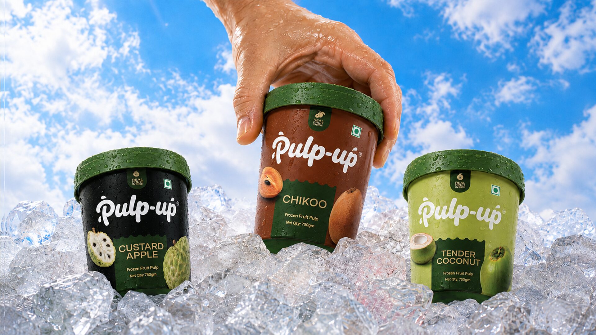 Custard apple, chikoo and tender coconut tubs resting on ice under a blue sky